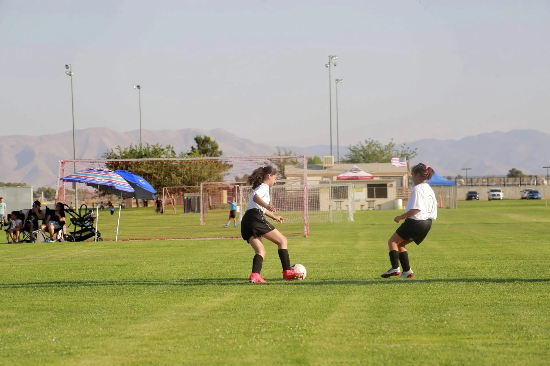 Soccer players in action on a green field, demonstrating teamwork and athleticism, highlighting the importance of mouthguards for safety in sports.